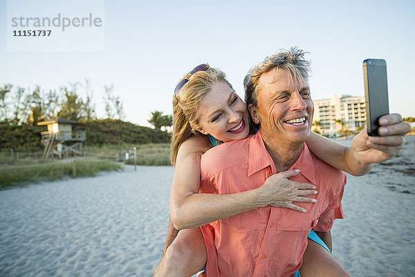 Älteres kaukasisches Paar macht Handy-Selfie am Strand