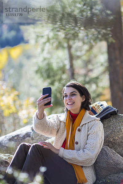 Gemischtrassiger Wanderer macht Handy-Selfie im Wald