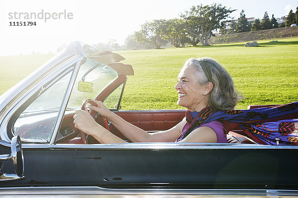 Kaukasische Frau fährt klassisches Cabrio