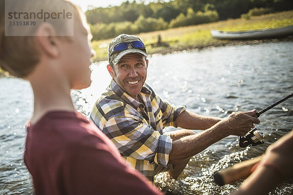 Kaukasischer Vater und Sohn beim Fischen im Fluss