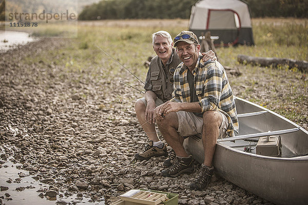 Kaukasischer Vater und Sohn sitzen im Kanu auf dem Campingplatz