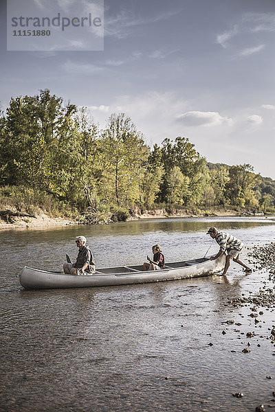 Drei Generationen kaukasischer Männer im Kanu auf dem Fluss