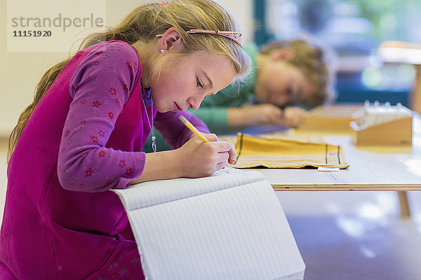 Kaukasisches Mädchen schreibt im Klassenzimmer