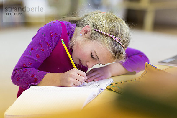 Kaukasisches Mädchen schreibt im Klassenzimmer