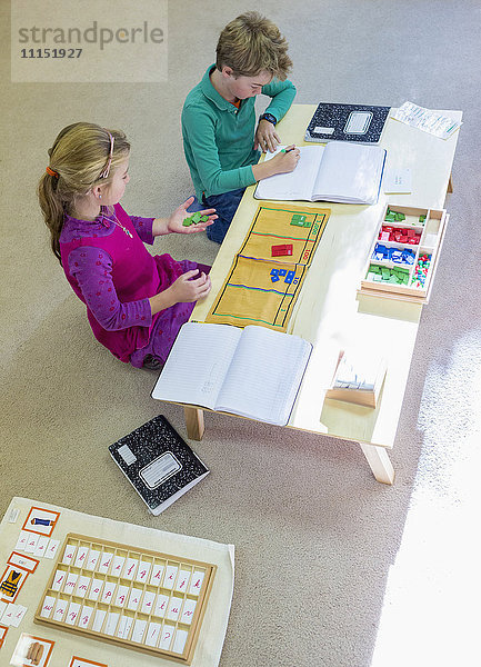 Kaukasische Kinder am Tisch im Klassenzimmer