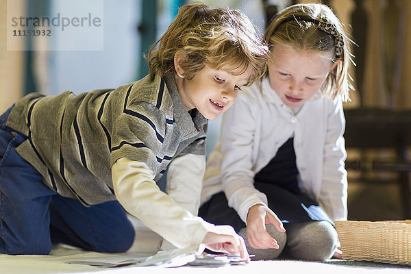 Kinder arbeiten gemeinsam auf dem Boden im Klassenzimmer