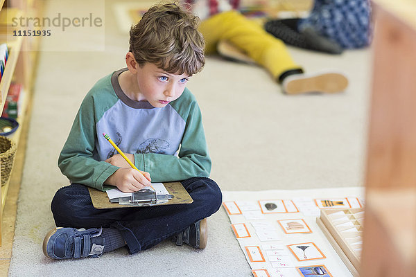 Junge schreibt im Klassenzimmer