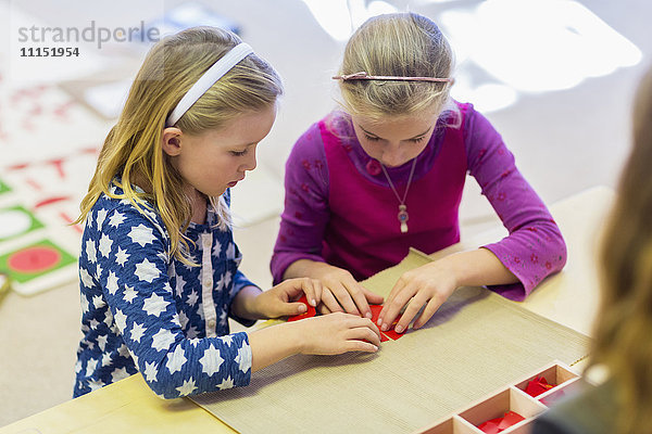 Kaukasische Mädchen arbeiten im Klassenzimmer zusammen