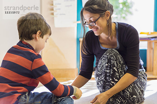 Montessori-Lehrerin hilft Schülerin im Klassenzimmer