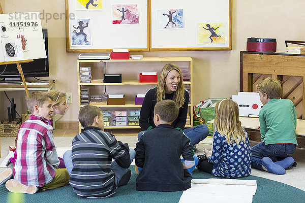 Montessori-Lehrer im Gespräch mit Schülern im Klassenzimmer