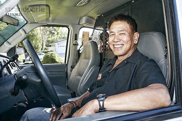 Klempner aus dem pazifischen Raum lächelt im Lieferwagen