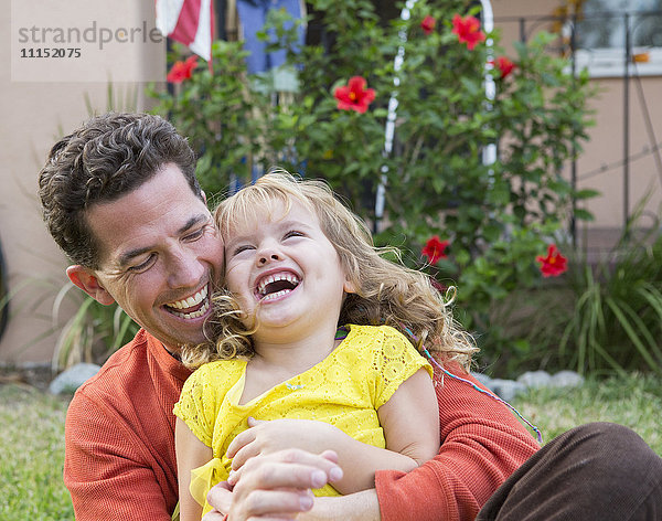 Kaukasischer Vater und Tochter spielen im Hinterhof