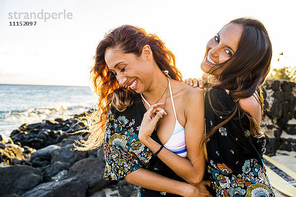 Lachende Frauen am felsigen Strand