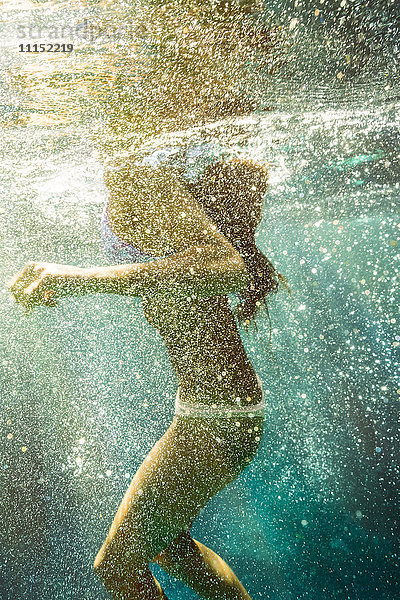 Gemischtrassige Frau schwimmt im Meer