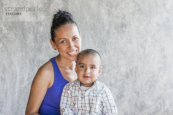 Lächelnde hispanische Mutter und Sohn