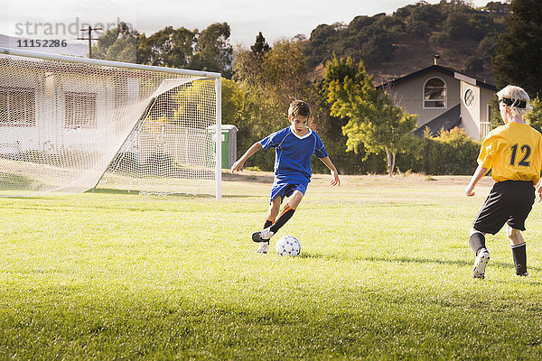 Jungen spielen Fußball auf einem Feld