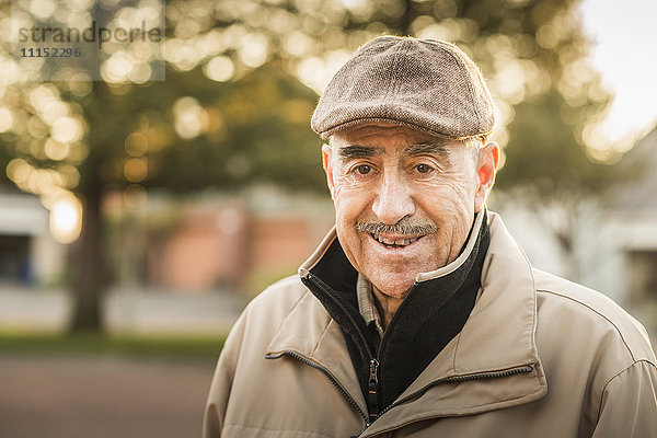 Älterer hispanischer Mann lächelt im Freien