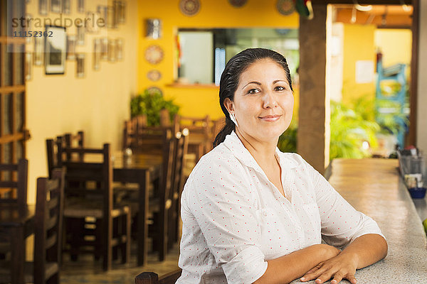 Lächelnde Frau am Tresen eines Restaurants