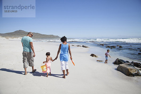 Gemischtrassige Familie beim Spaziergang am Strand