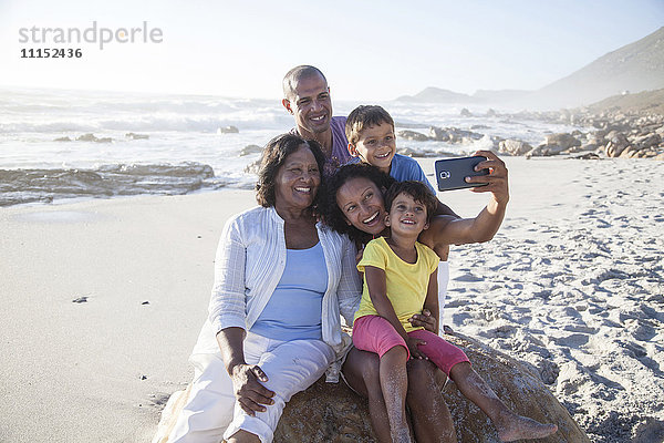 Gemischtrassige Mehrgenerationenfamilie macht Handy-Selfie am Strand