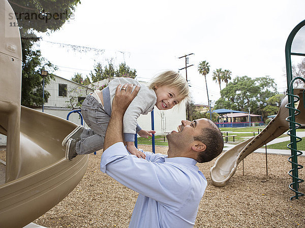 Hispanischer Vater und Sohn spielen auf dem Spielplatz