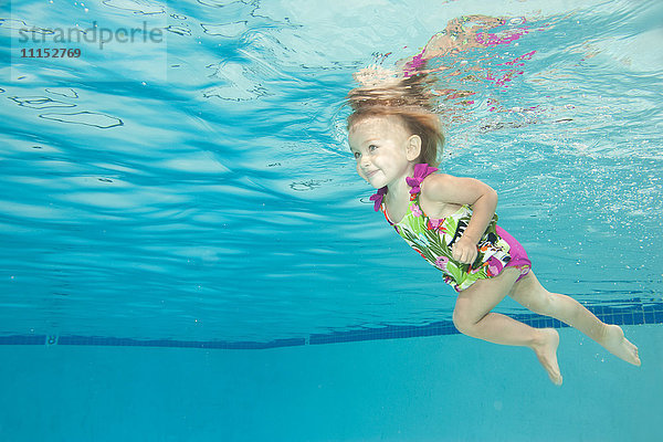 Unterwasseransicht eines kaukasischen Mädchens beim Schwimmen im Pool