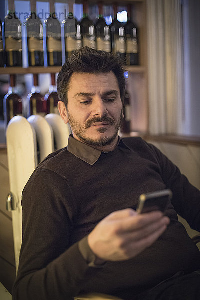 Kaukasischer Mann  der ein Mobiltelefon benutzt