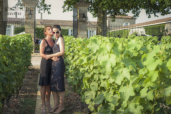 Kaukasisches lesbisches Paar umarmt sich im Weinberg