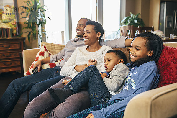Schwarze Familie beim Fernsehen auf dem Sofa