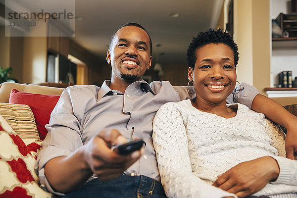 Schwarzes Paar beim Fernsehen auf dem Sofa