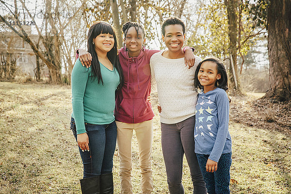 Schwarze Mutter und Töchter lächelnd im Freien