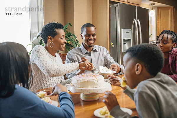 Schwarze Familie isst Kuchen bei Geburtstagsfeier