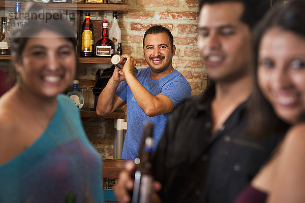 Hispanischer Barkeeper macht Getränke in einer Bar