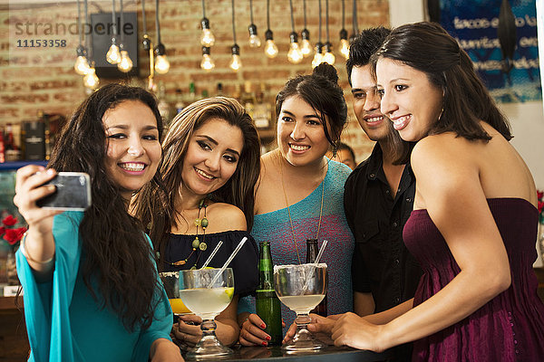 Hispanische Freunde machen ein Selfie in einer Bar