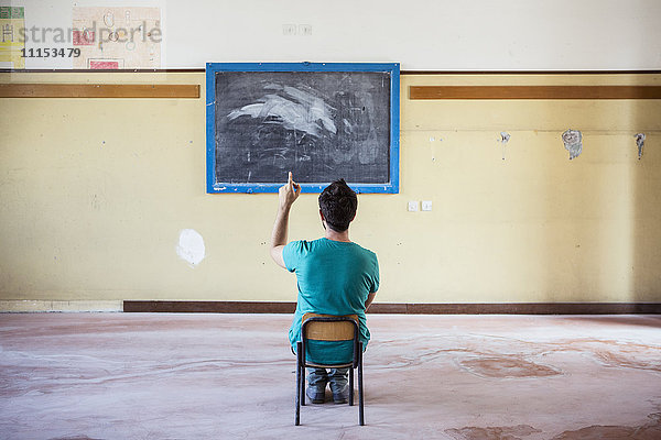 Kaukasischer Schüler sitzt in einem leeren Klassenzimmer