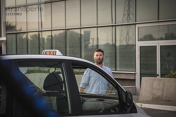 Kaukasischer Mann geht auf ein Taxi zu