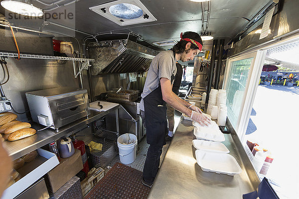 Kaukasischer Koch arbeitet in der Küche eines Food Trucks