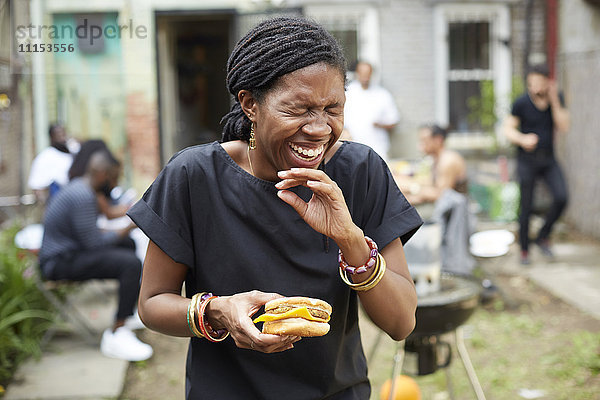 Afroamerikanische Frau beim Grillen im Hinterhof