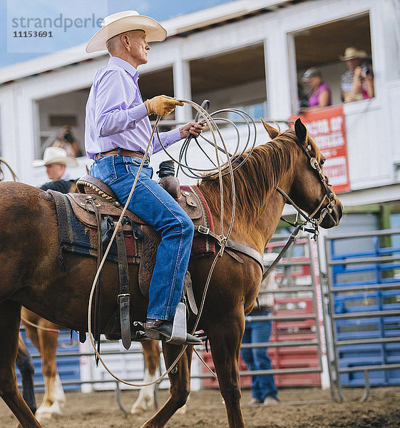 Kaukasischer Cowboy reitet Pferd beim Rodeo