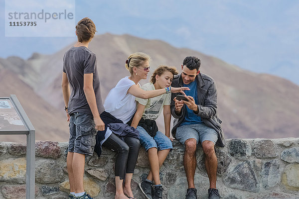 Familie benutzt Mobiltelefon im Nationalpark
