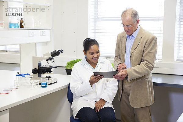 Geschäftsmann und Wissenschaftler verwenden digitales Tablet im Labor