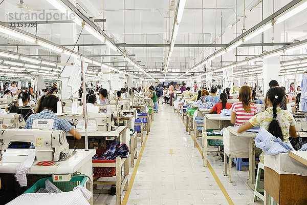 Asiatische Arbeiterin näht Kleidung in einer Bekleidungsfabrik