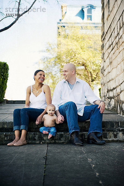 Familie sitzt auf den Stufen eines Stadtparks