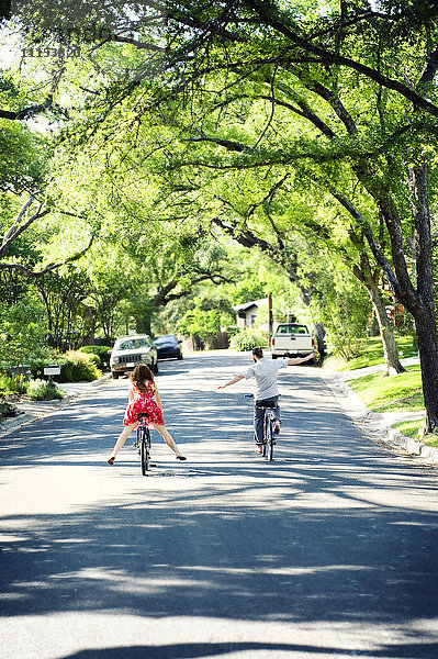 Weiße Kinder auf Fahrrädern in einer Straße in einem Vorort