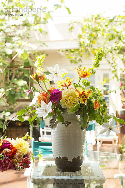 Blumenstrauß in Vase auf Hinterhof-Terrasse