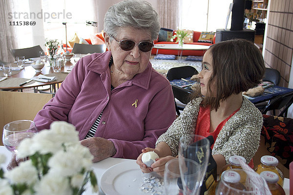 Großmutter und Enkelin kochen am Tisch