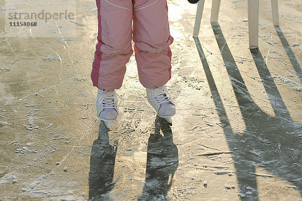 Kaukasisches Mädchen beim Schlittschuhlaufen auf gefrorenem Eis