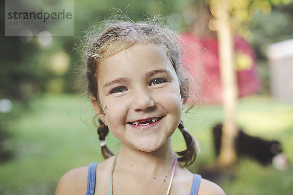 Kaukasisches Mädchen lächelnd im Hinterhof