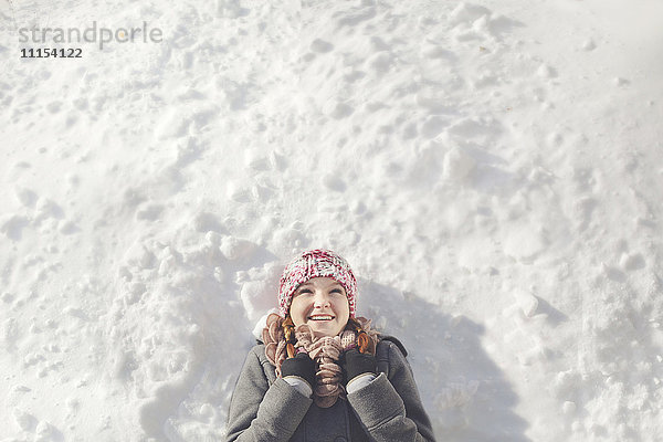 Kaukasisches Mädchen liegt im Schnee