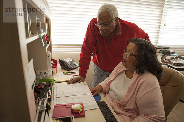 Ehepaar benutzt Computer im Heimbüro